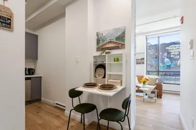 a kitchen and living room with a table and chairs at Apartment MTL Dtown Spotlight MTL in Montréal