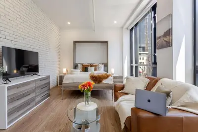 a living room with a couch and a bed and a laptop at Apartment MTL Dtown Spotlight MTL in Montréal