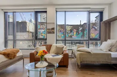 a living room with a couch and a table and windows at Apartment MTL Dtown Spotlight MTL in Montréal