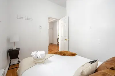 a bedroom with a bed with a cat on it at Premium Location Stylish 3BR downtown Montreal in Montréal