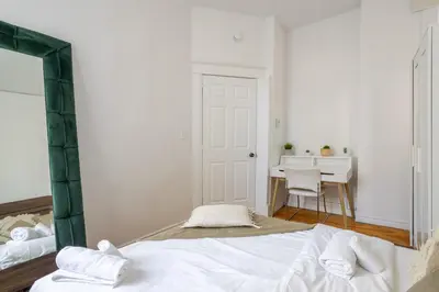 a white bedroom with a bed and a desk at Premium Location Stylish 3BR downtown Montreal in Montréal