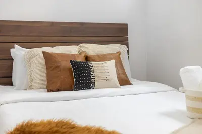 a bed with a bunch of pillows on it at Premium Location Stylish 3BR downtown Montreal in Montréal