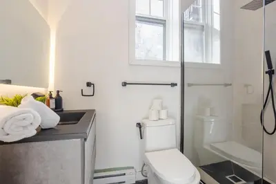 a bathroom with a toilet and a sink and a shower at Premium Location Stylish 3BR downtown Montreal in Montréal