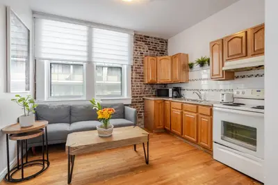 a kitchen with a couch and a table in a room at Premium Location Stylish 3BR downtown Montreal in Montréal