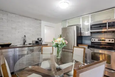 a kitchen with a glass table with a vase of flowers at Artful 3BR in Montreal Village in Montréal