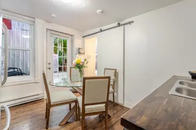 a kitchen and dining room with a glass table and chairs at Artful 3BR in Montreal Village in Montréal