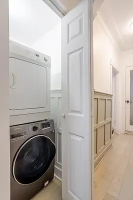 a laundry room with a washing machine and a white door at Artful 3BR in Montreal Village in Montréal