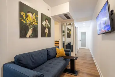 a living room with a blue couch and a flat screen tv at Spacious 3BR in the heart of Village in Montréal