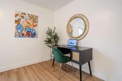a black desk with a mirror and a green chair at Spacious 3BR in the heart of Village in Montréal
