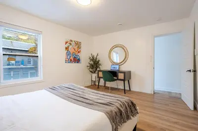 a bedroom with a bed and a mirror and a desk at Spacious 3BR in the heart of Village in Montréal