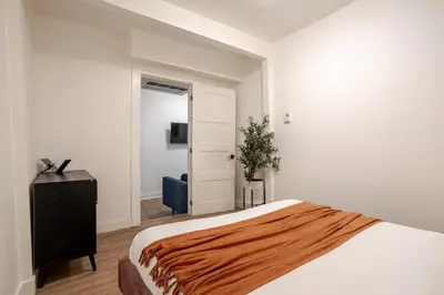a bedroom with a bed and a television and a door at Spacious 3BR in the heart of Village in Montréal