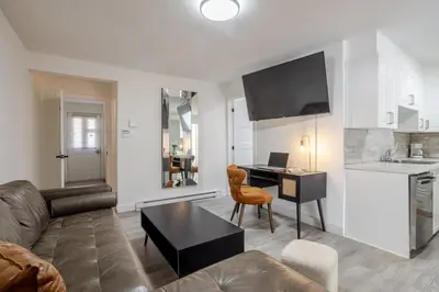 a living room with a couch and a table and a desk at Stylish 3BR in Montreal Village in Montréal