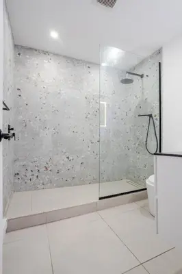 a bathroom with a shower with a glass door at Stylish 3BR in Montreal Village in Montréal