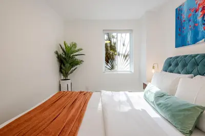 a white living room with a couch and a plant at Stylish 3BR in Montreal Village in Montréal