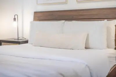 a bed with white sheets and pillows in a room at Stylish 3BR in Montreal Village in Montréal