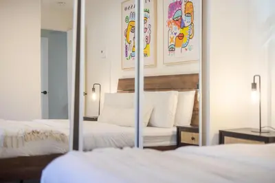 a bedroom with two beds and a mirror at Stylish 3BR in Montreal Village in Montréal
