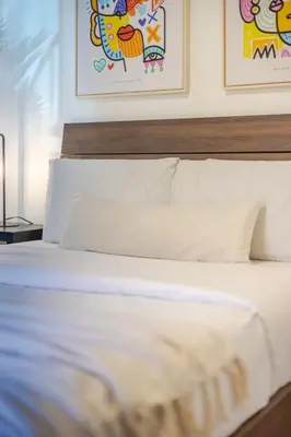 a bedroom with a white bed with paintings on the wall at Stylish 3BR in Montreal Village in Montréal