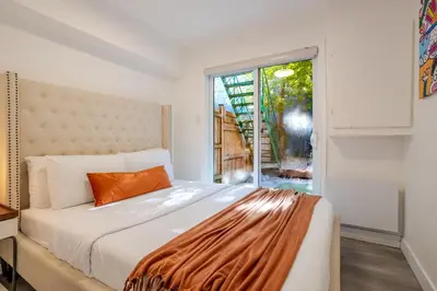 a bedroom with a bed and a large window at Stylish 3BR in Montreal Village in Montréal