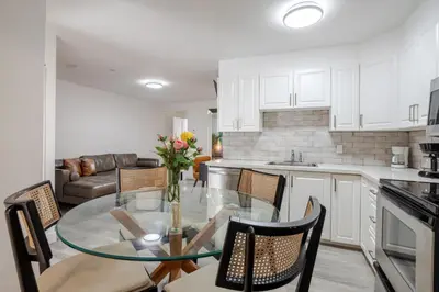 a kitchen and dining room with a glass table and chairs at Stylish 3BR in Montreal Village in Montréal