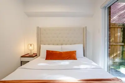 a bed with an orange pillow on it in a bedroom at Stylish 3BR in Montreal Village in Montréal