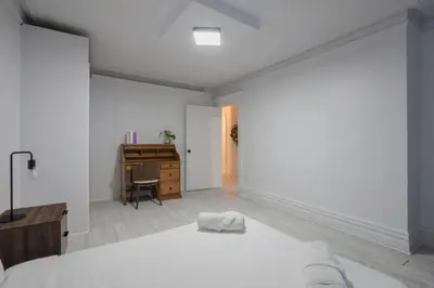 a white bedroom with a bed and a desk at Grand Urban 4BR Luxe Loft in Griffintown in Montréal