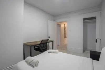a bedroom with two beds and a desk and a chair at Grand Urban 4BR Luxe Loft in Griffintown in Montréal