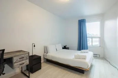 a bedroom with a bed and a desk and a window at Grand Urban 4BR Luxe Loft in Griffintown in Montréal