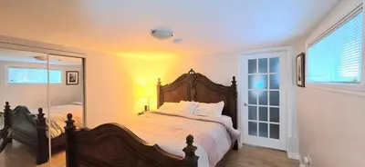 a bedroom with a large bed and a mirror at The Home Sweet Home 20 Mnt away From Airport in Vaudreuil-Dorion