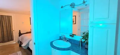 a blue bathroom with a sink and a bed at The Home Sweet Home 20 Mnt away From Airport in Vaudreuil-Dorion