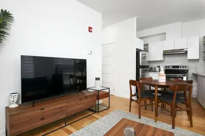 a living room with a large television and a table at Peaceful 2BR Getaway in Downtown in Montréal