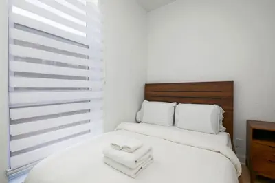 a bedroom with a white bed with two towels on it at Peaceful 2BR Getaway in Downtown in Montréal