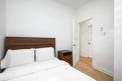 a bedroom with a white bed with a wooden headboard at Peaceful 2BR Getaway in Downtown in Montréal