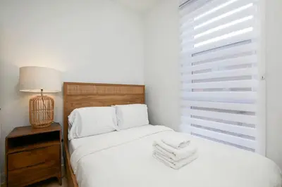 a bedroom with a bed and a lamp and a window at Peaceful 2BR Getaway in Downtown in Montréal