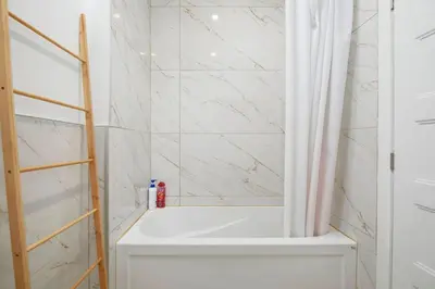 a bathroom with a shower with a white shower curtain at Peaceful 2BR Getaway in Downtown in Montréal