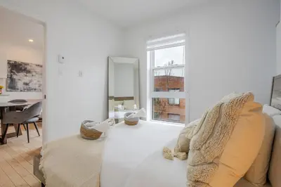 a white room with a bed and a window at Outstanding 1BR village downtown MTL in Montréal