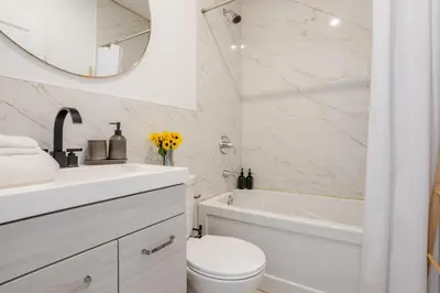 a white bathroom with a sink toilet and a mirror at Outstanding 1BR village downtown MTL in Montréal