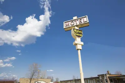 a motel sign on top of a pole at Motel Vaudreuil in Vaudreuil-Dorion
