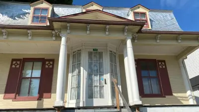 a house with white columns and a large window at Propre Confortable Près des services in Saint-Joseph-de-Beauce
