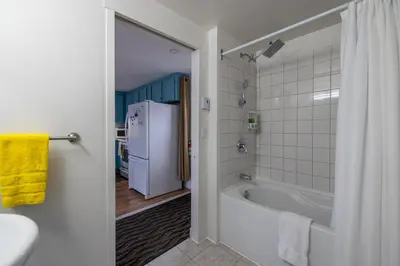 a bathroom with a tub and a refrigerator at Propre Confortable Près des services in Saint-Joseph-de-Beauce