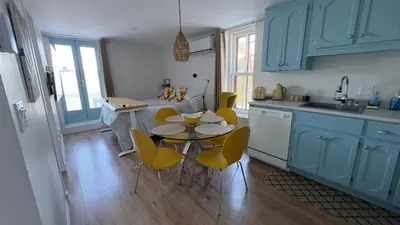 a kitchen with blue cabinets and a table and chairs at Propre Confortable Près des services in Saint-Joseph-de-Beauce