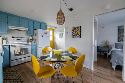 a kitchen with a dining table and yellow chairs at Propre Confortable Près des services in Saint-Joseph-de-Beauce