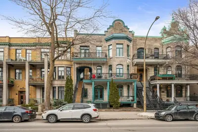 a large building with cars parked in front of it at Stylish loft in heart of Plateau in Montréal
