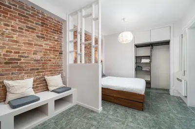 a bedroom with a bed and a brick wall at Stylish loft in heart of Plateau in Montréal