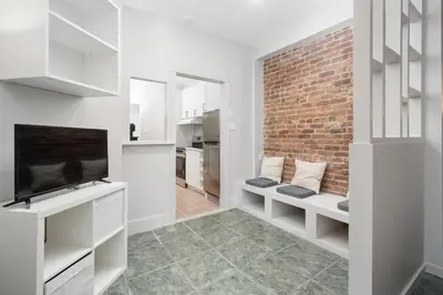 a living room with white cabinets and a brick wall at Stylish loft in heart of Plateau in Montréal