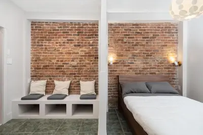 a bedroom with a bed against a brick wall at Stylish loft in heart of Plateau in Montréal