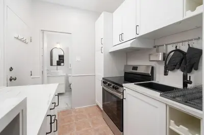 a white kitchen with a sink and a stove at Stylish loft in heart of Plateau in Montréal