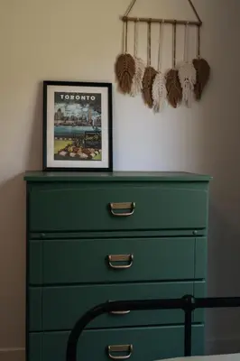 a green dresser with a picture on the wall at Le Fitzsimmons in Mansonville