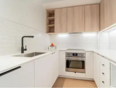 a white kitchen with a sink and a stove at Relaxing 2 bedrooms Spa in Montréal