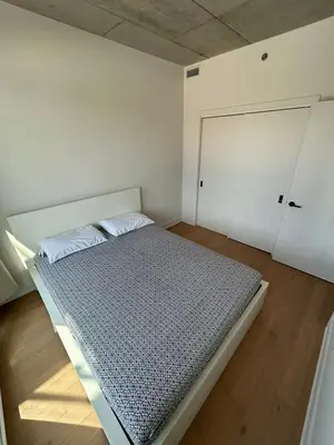 a white bedroom with a bed and a closet at Relaxing 2 bedrooms Spa in Montréal