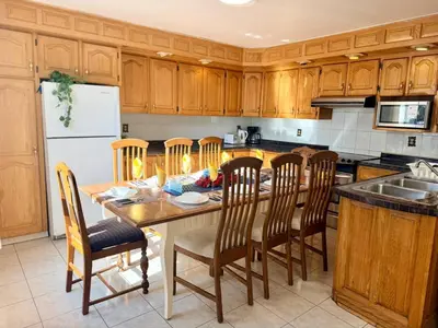 a kitchen with a table with chairs and a refrigerator at City Lights Loft-Free Parking-Sleep 18 in Montréal